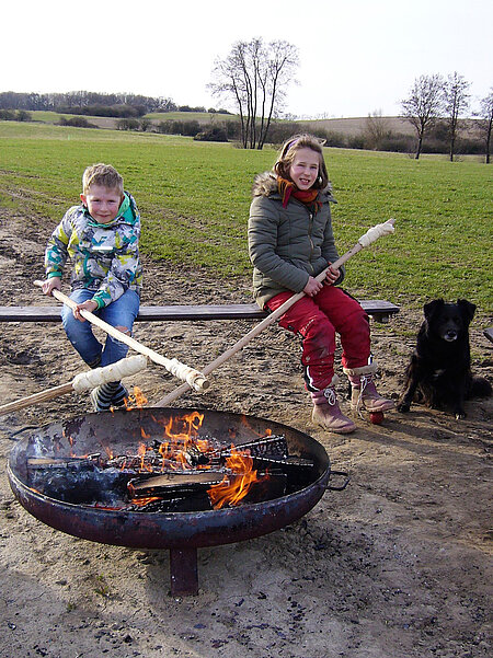 Kinder machen Stockbrot.