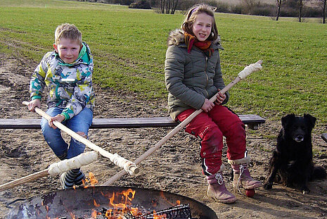 Kinder machen Stockbrot.